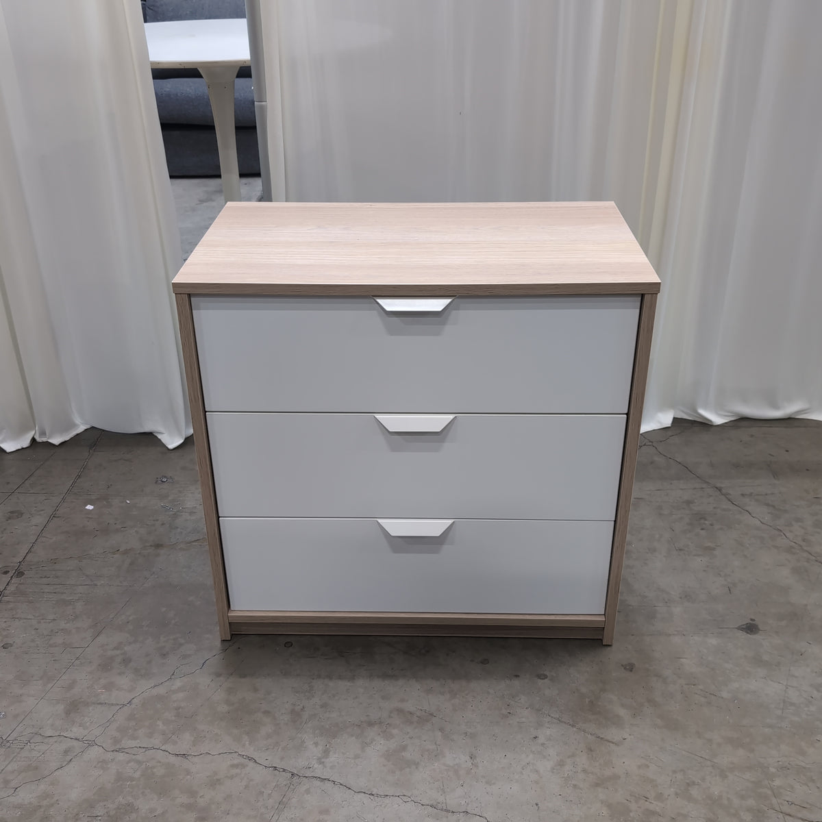 Light Wood Three-Drawer Nightstand with Recessed Pulls