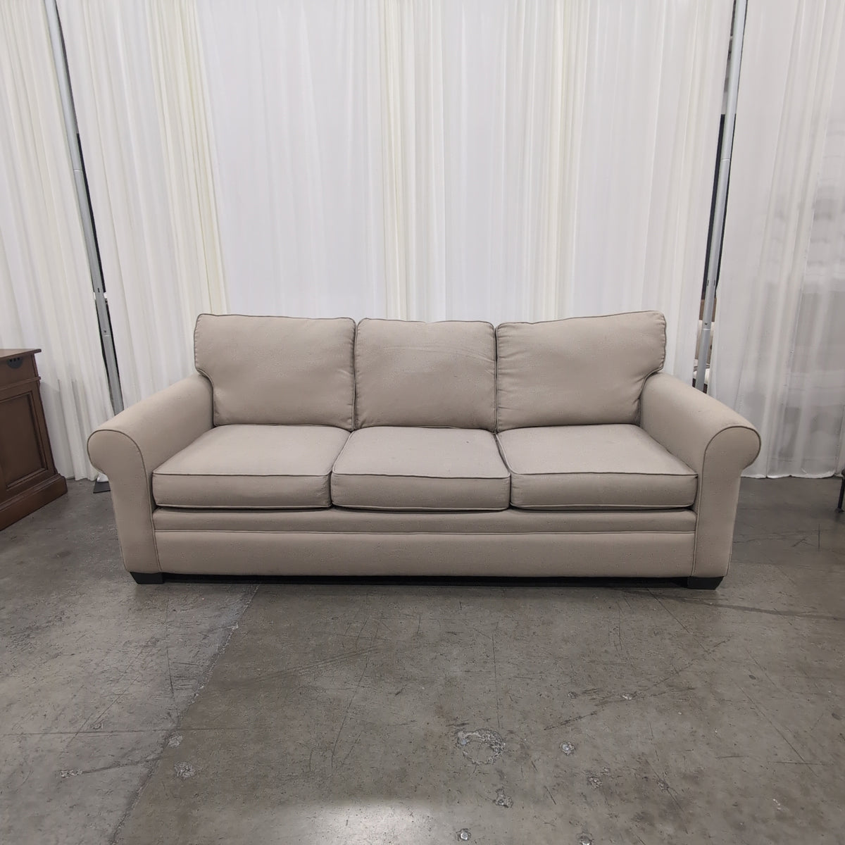 Tan Fabric Three-Cushion Couch with Rolled Arms