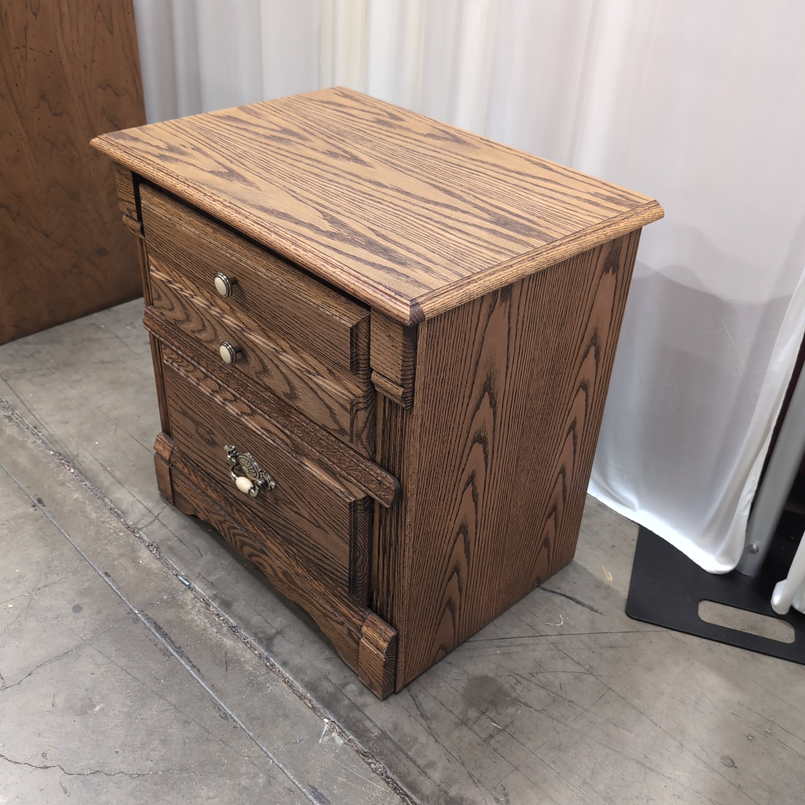 Brown Wood Three-Drawer Nightstand with Ornate Hardware