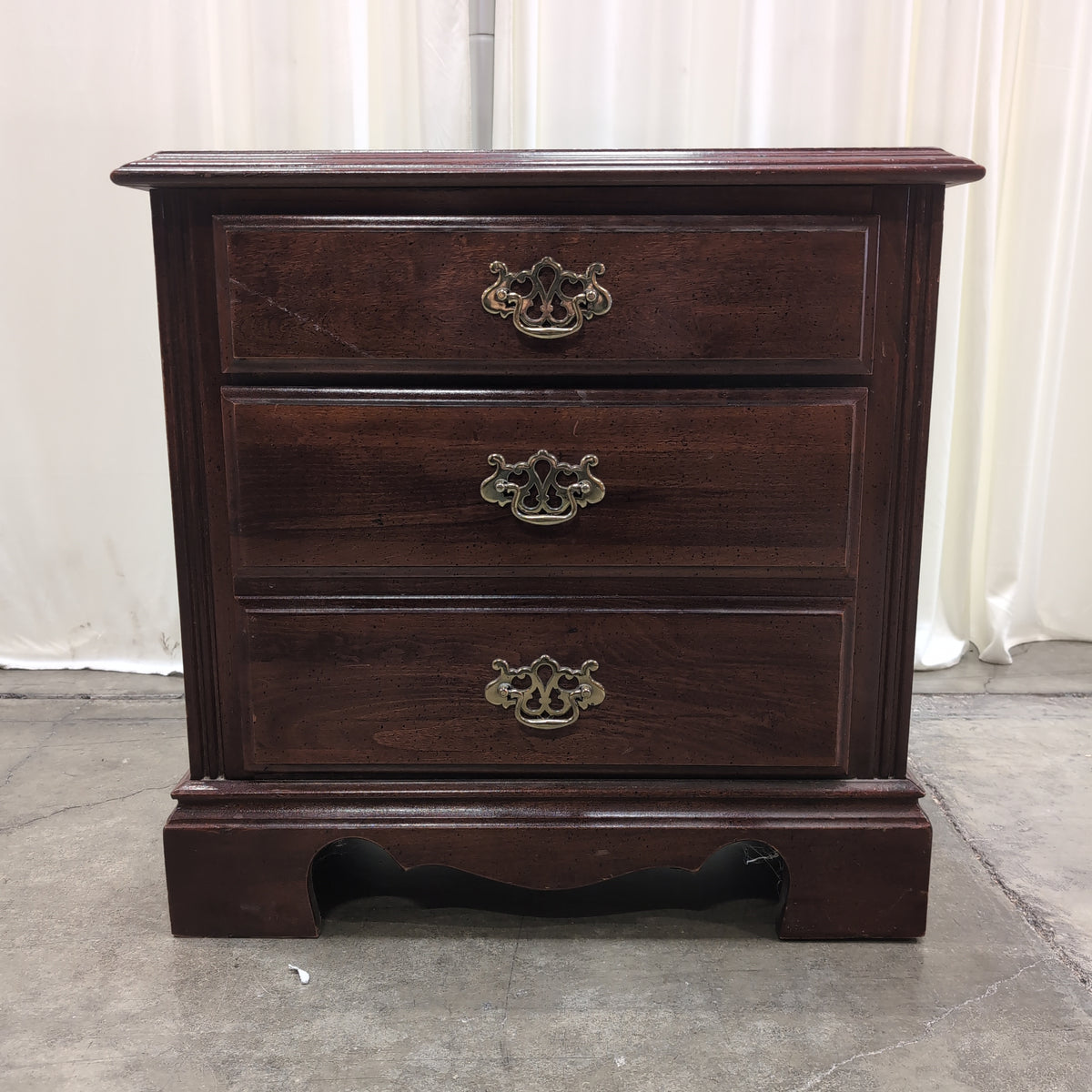 Traditional Dark Wood Three-Drawer Nightstand with Ornate Hardware