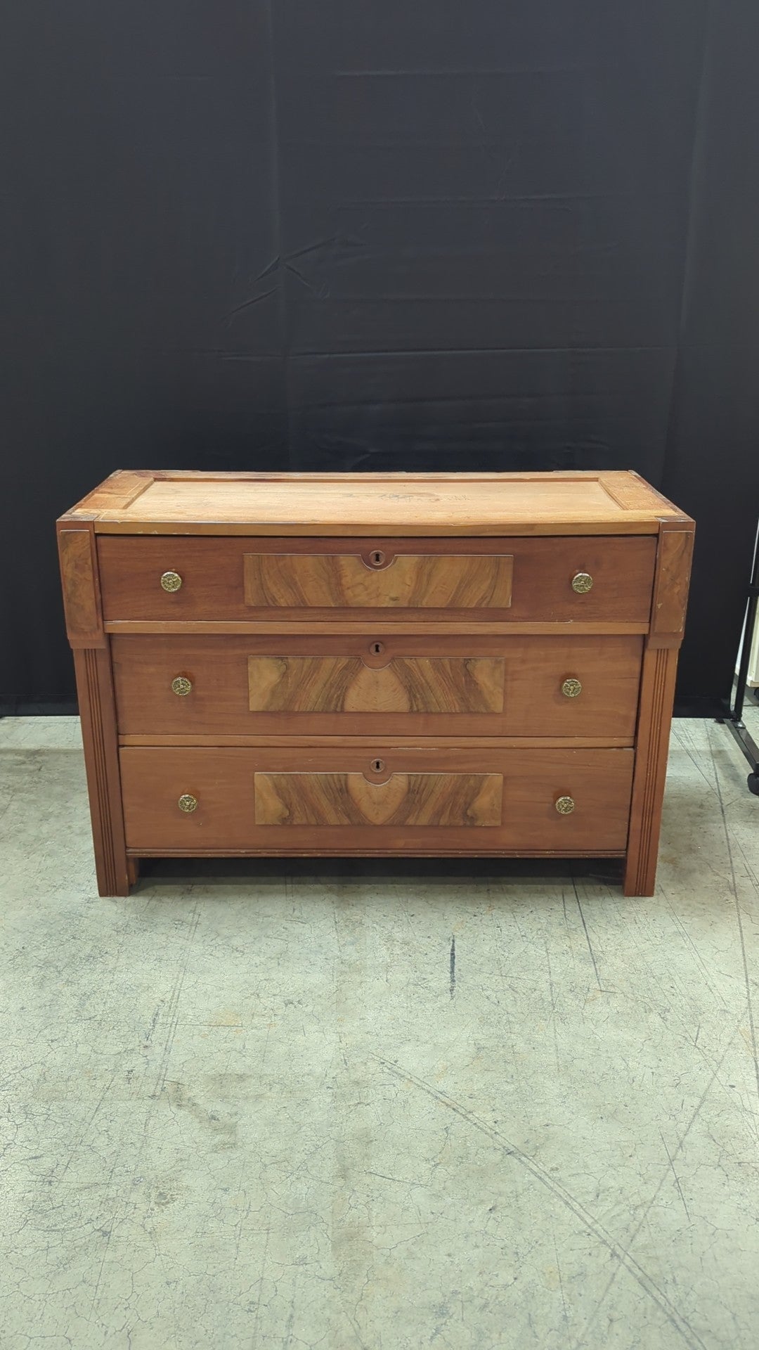 Warm Wood Three-Drawer Dresser with Ornate Hardware