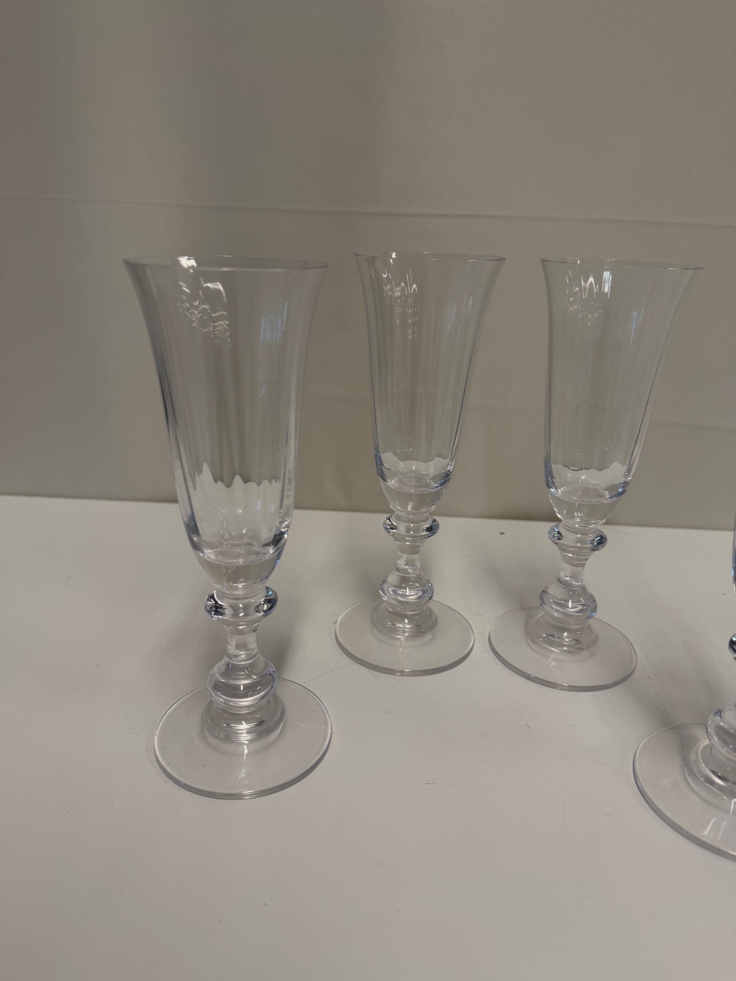 Four Clear Ribbed Glass Champagne Flutes with Decorative Stems
