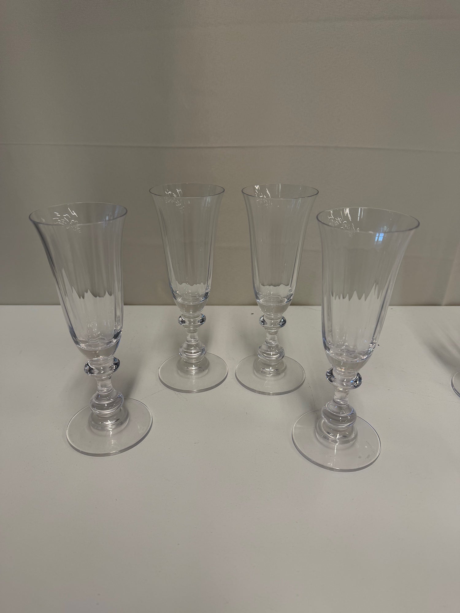 Four Clear Ribbed Glass Champagne Flutes with Decorative Stems