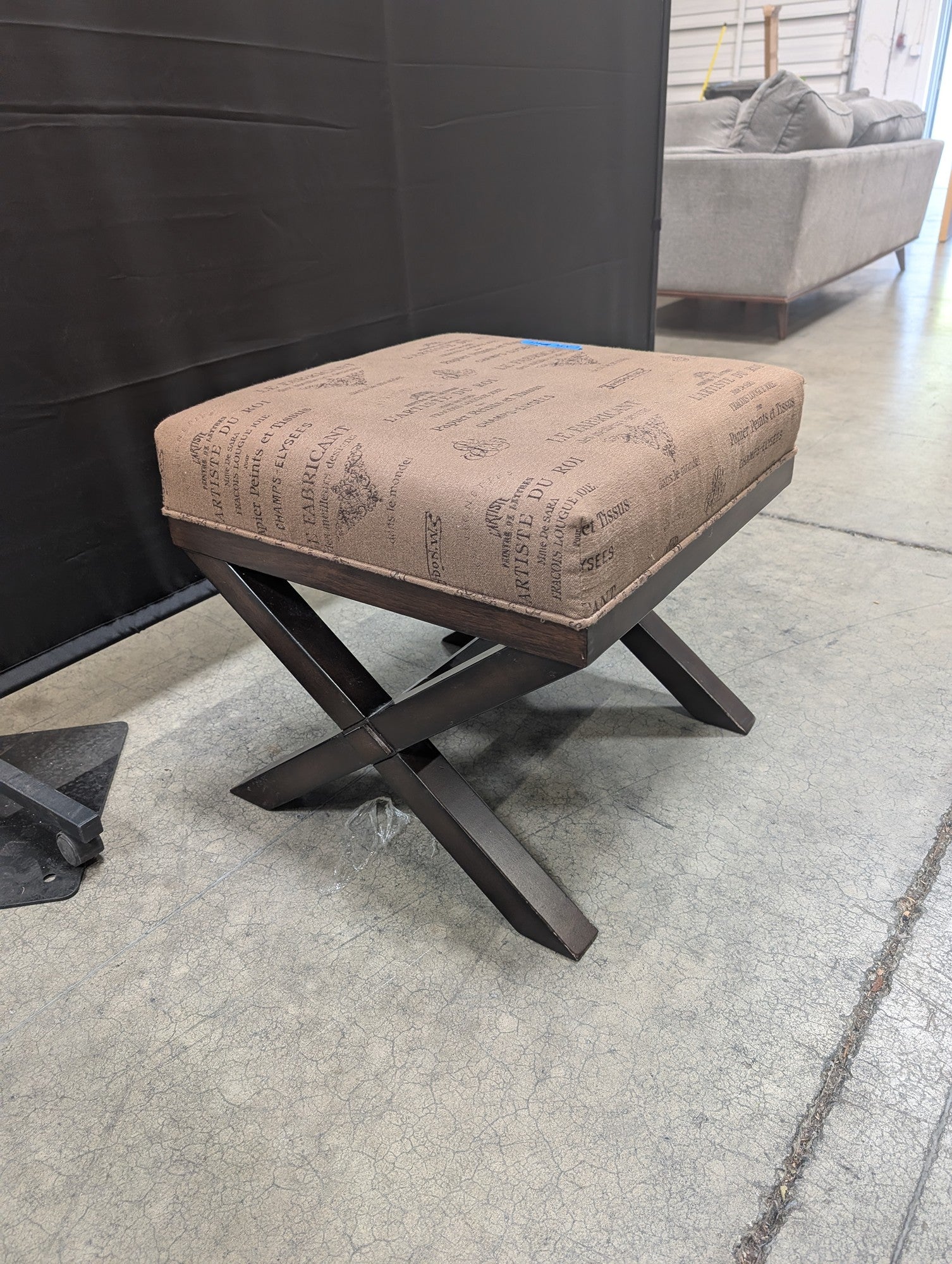 Ashley French Script Upholstered Ottoman with X-Base