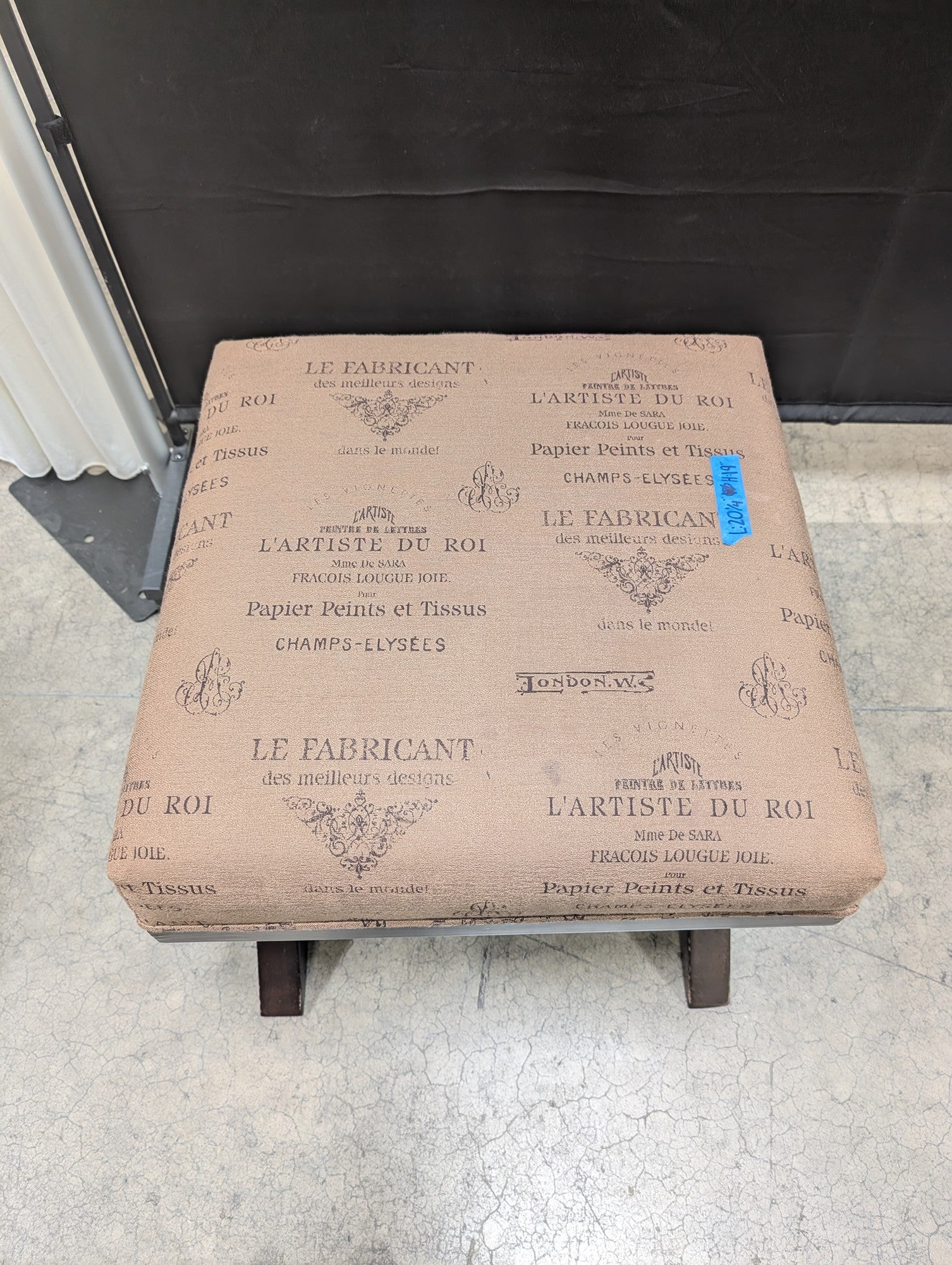 Ashley French Script Upholstered Ottoman with X-Base