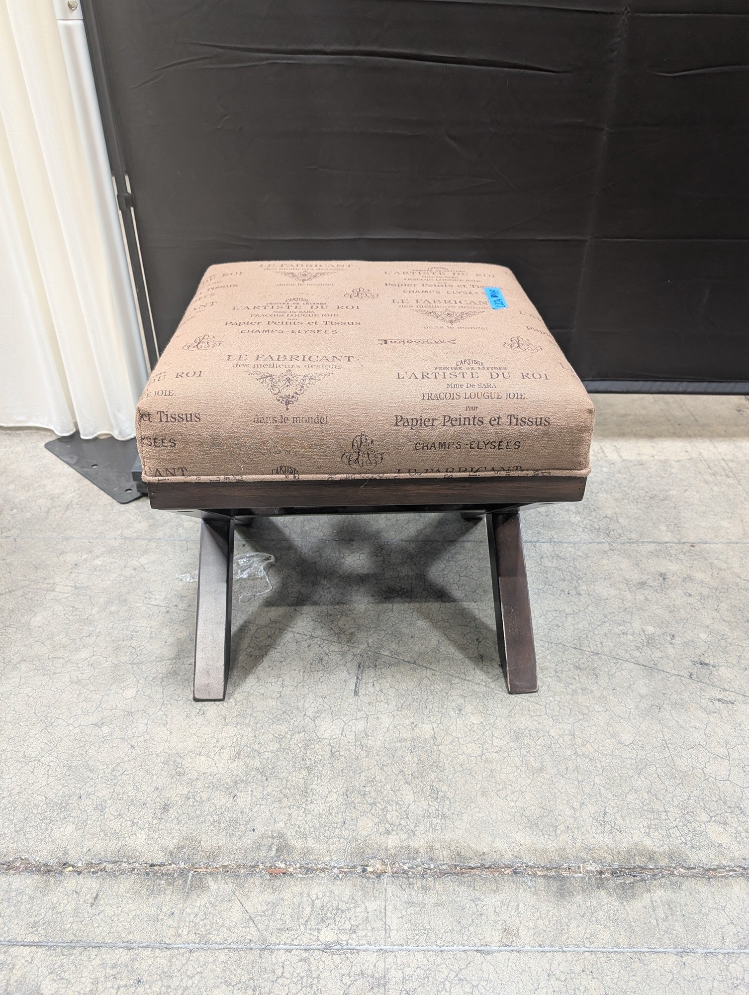 Ashley French Script Upholstered Ottoman with X-Base