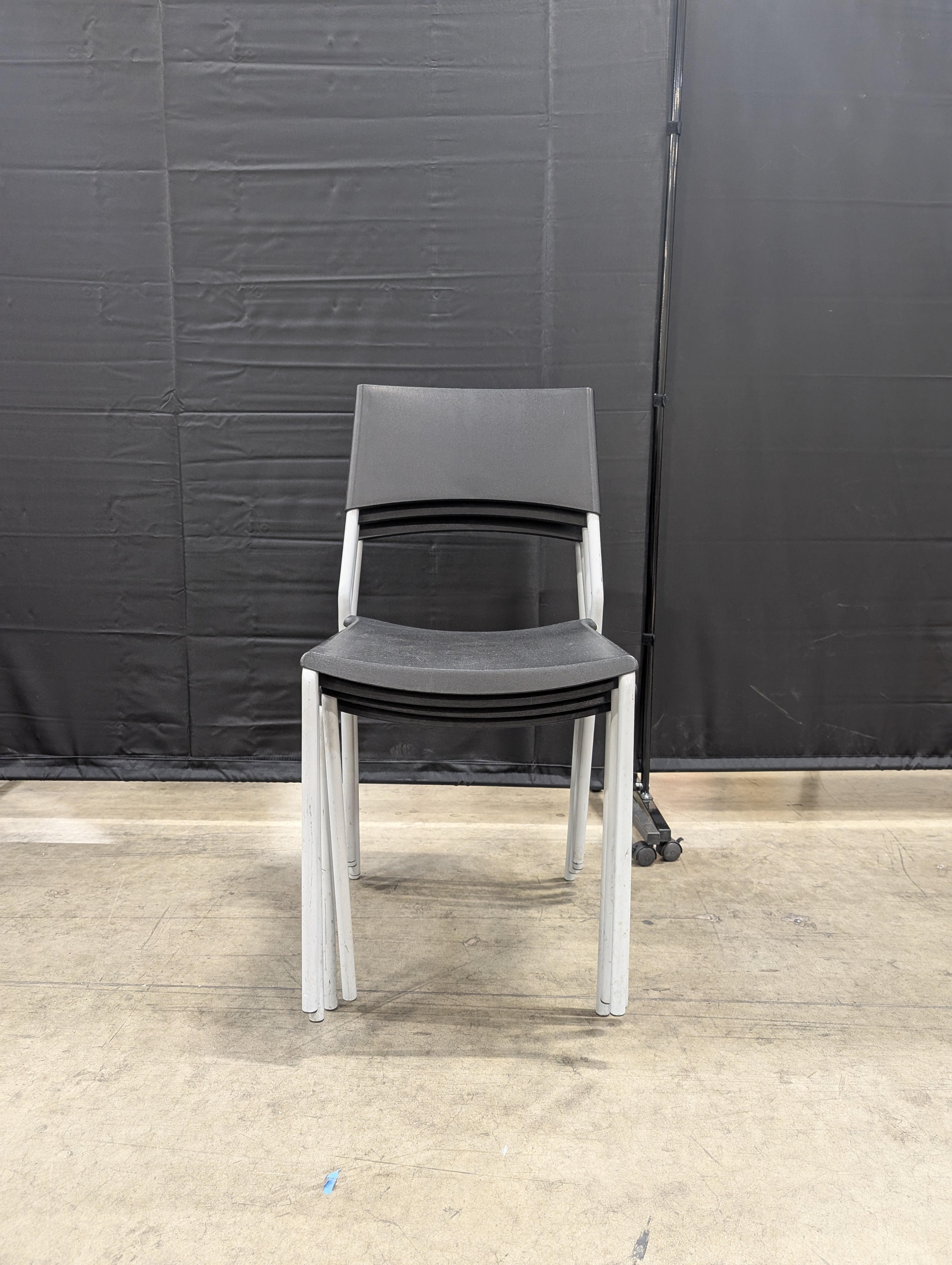 Set of Four Modern Black Stacking Chairs with Metal Frames