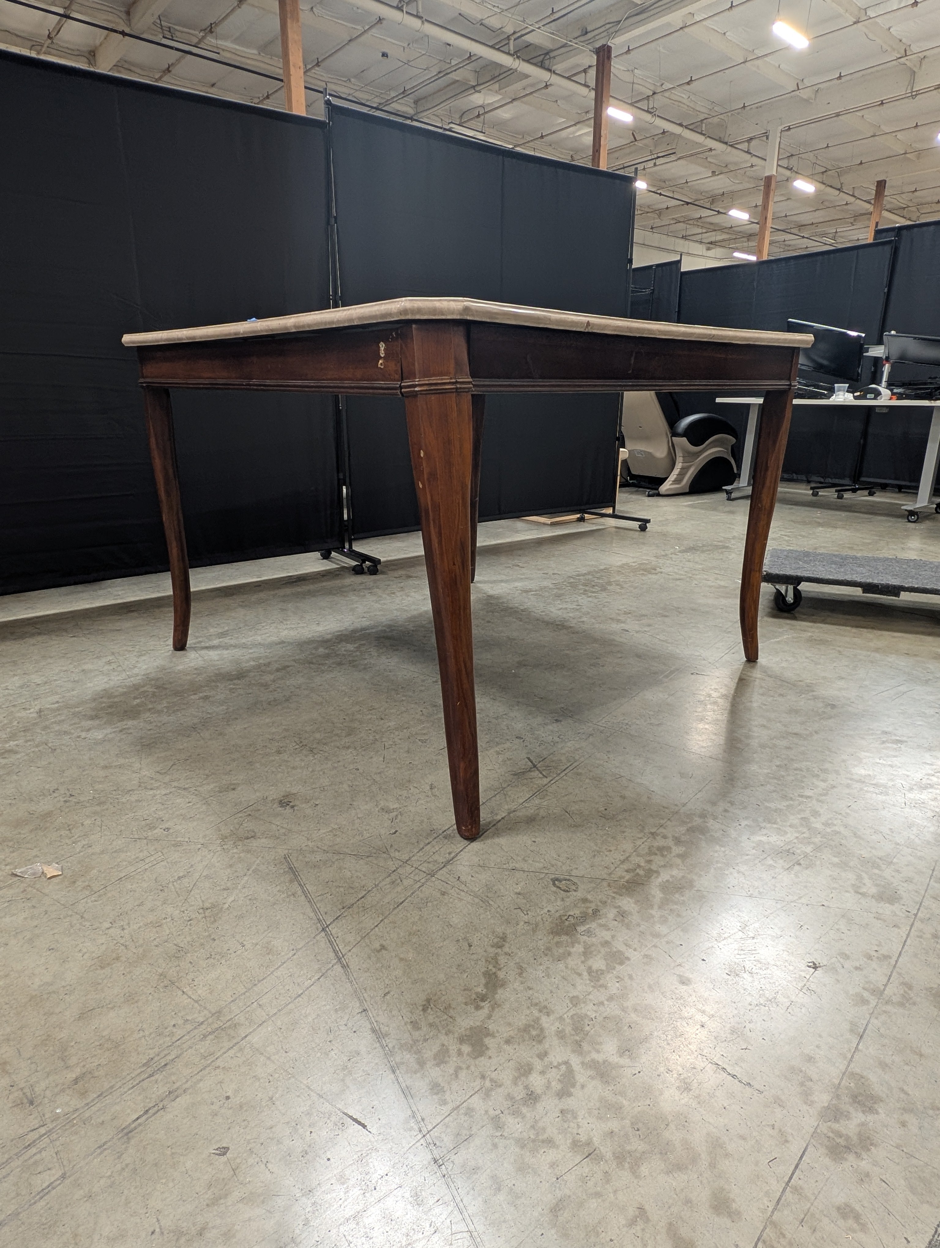 Stone Top Dining Table with Tapered Wood Legs has chip