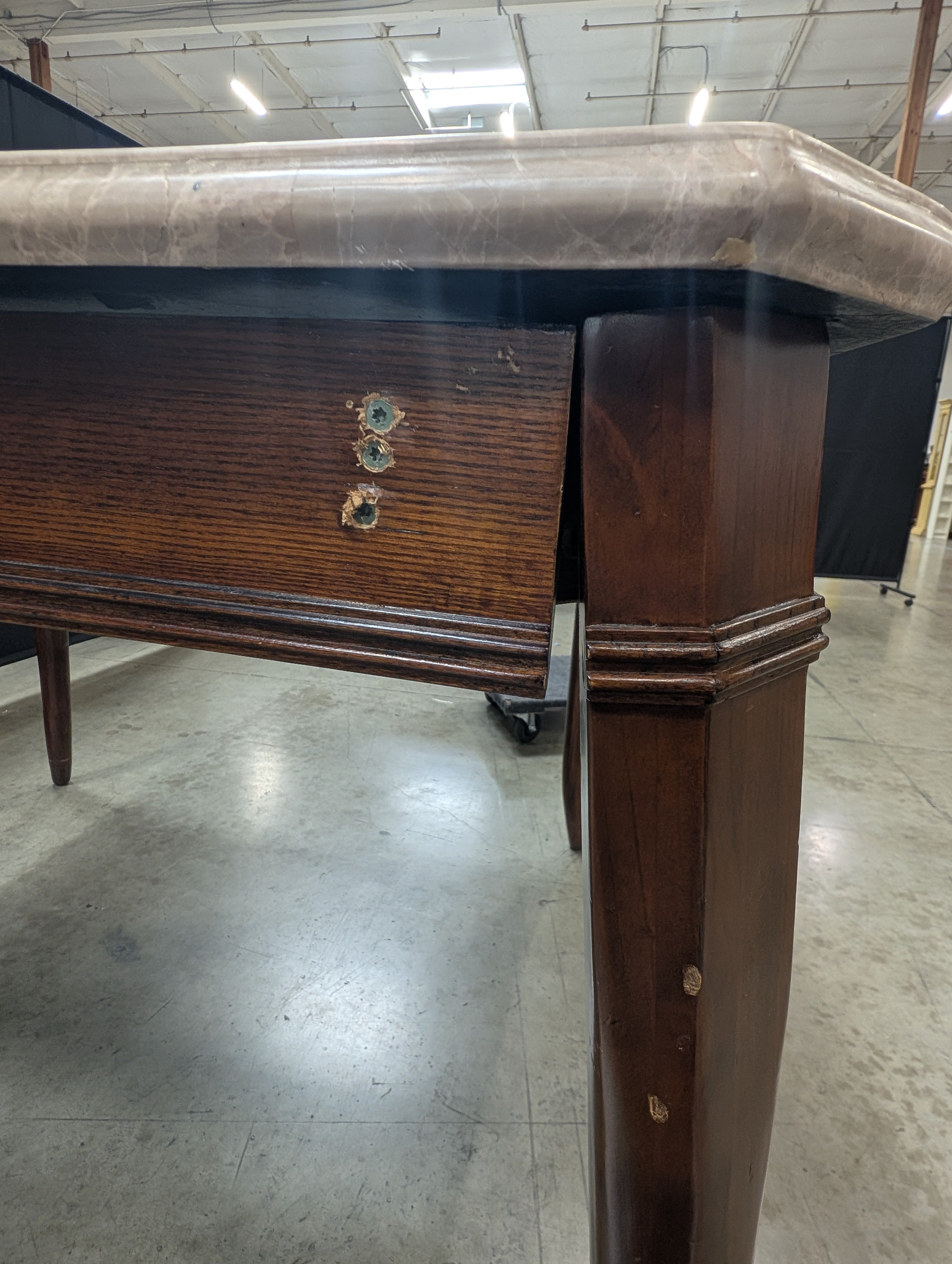 Stone Top Dining Table with Tapered Wood Legs has chip