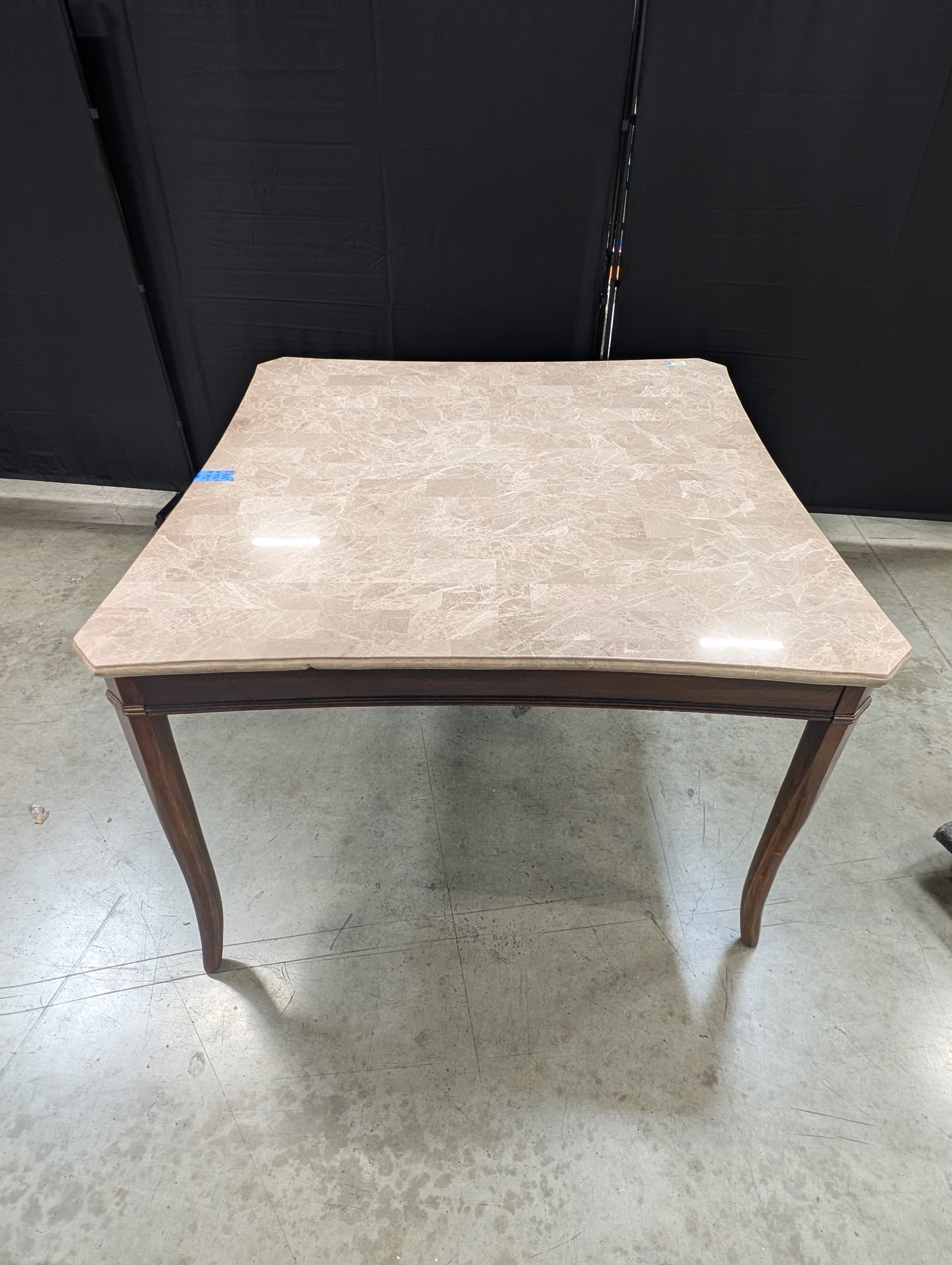 Stone Top Dining Table with Tapered Wood Legs has chip