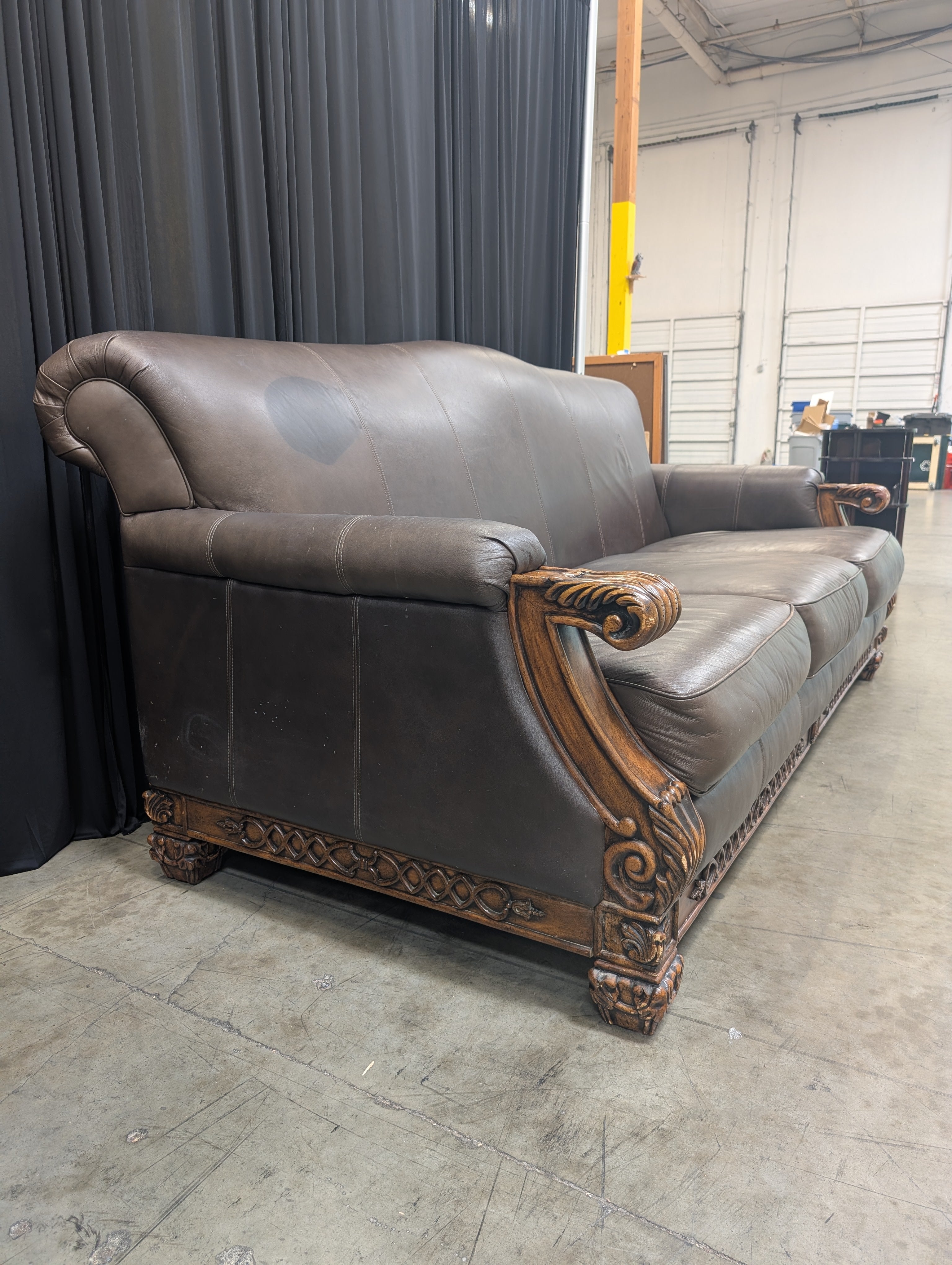 Ornate Brown Leather Couch with Carved Wood Trim