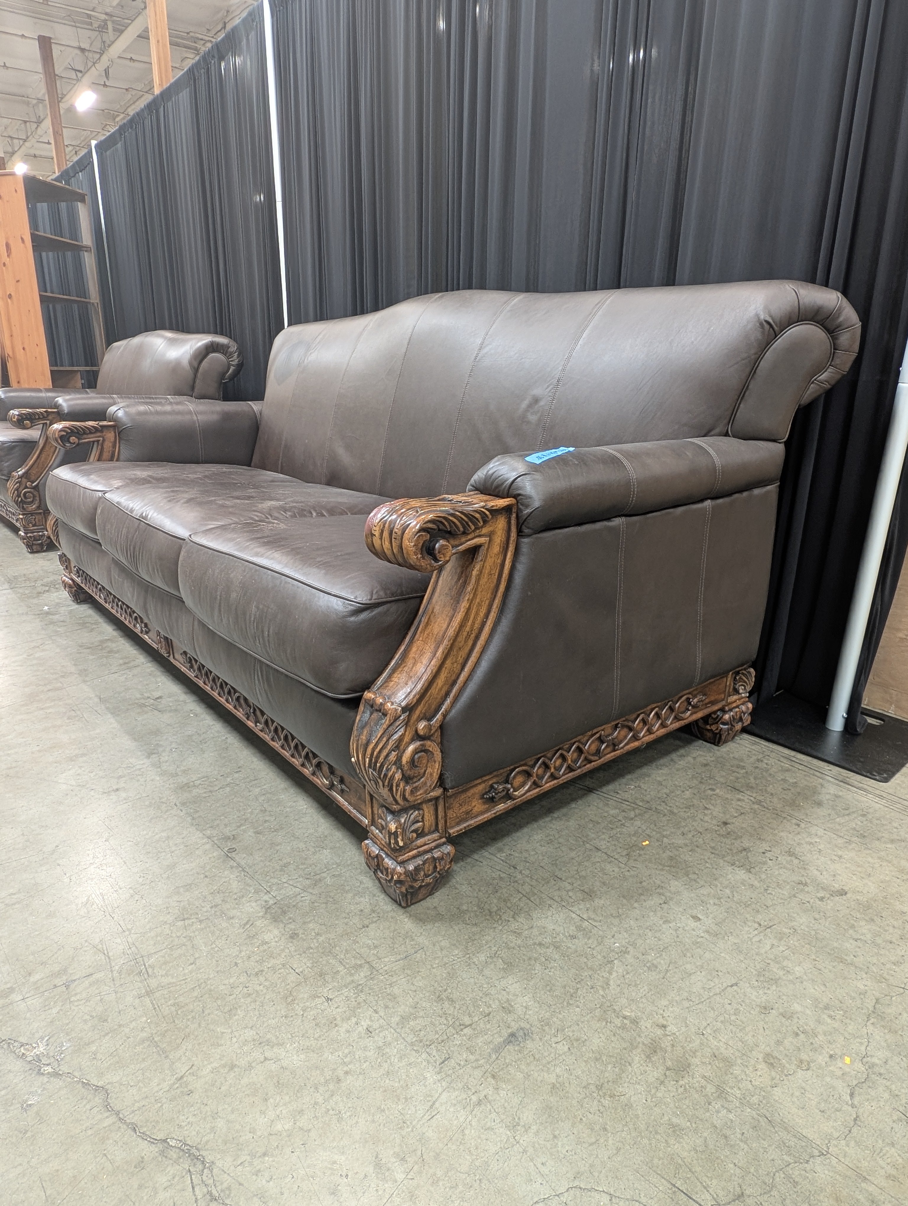 Ornate Brown Leather Couch with Carved Wood Trim