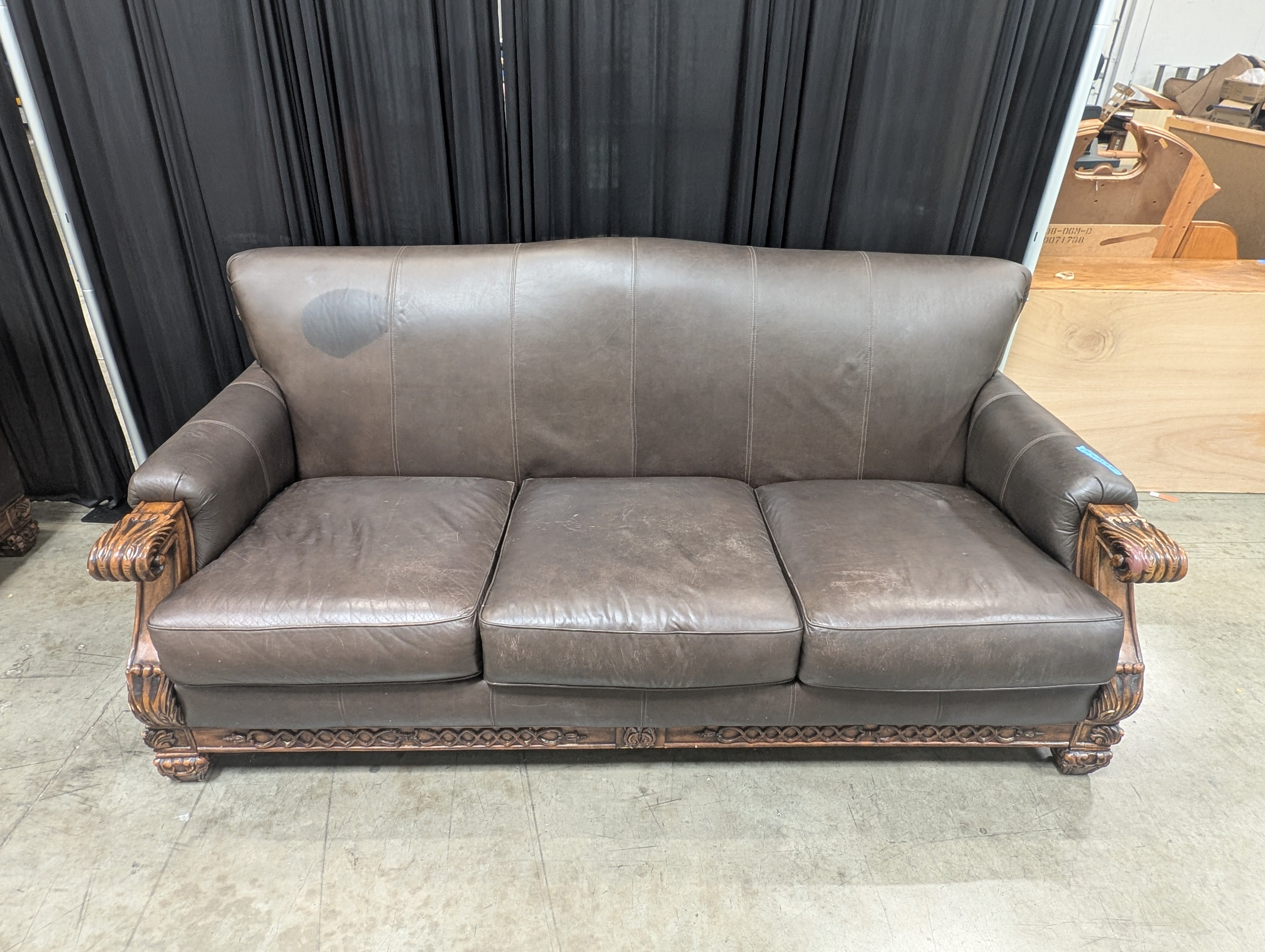 Ornate Brown Leather Couch with Carved Wood Trim