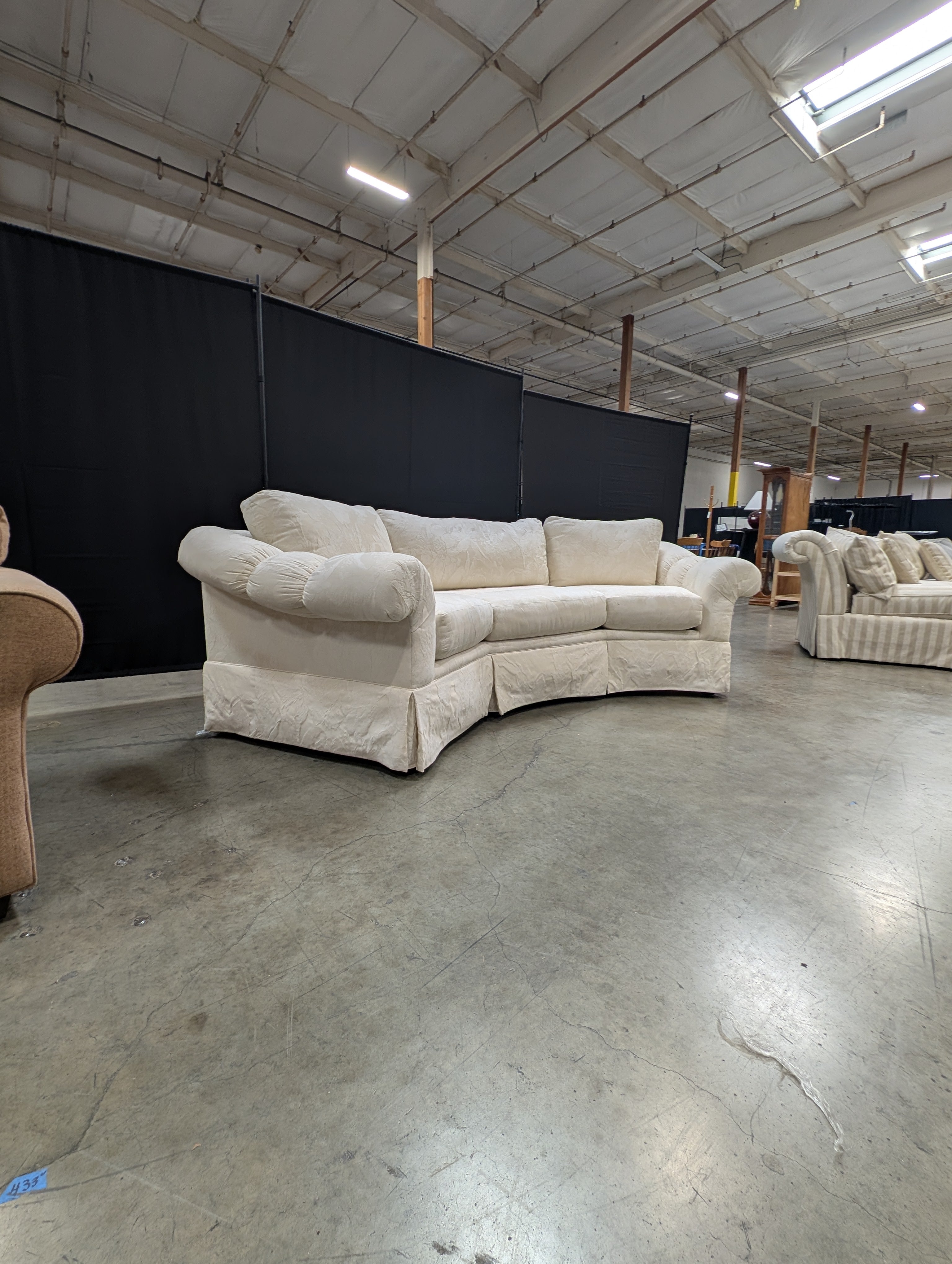 Has a stain Curved Cream Fabric Sectional Sofa with Rolled Arms