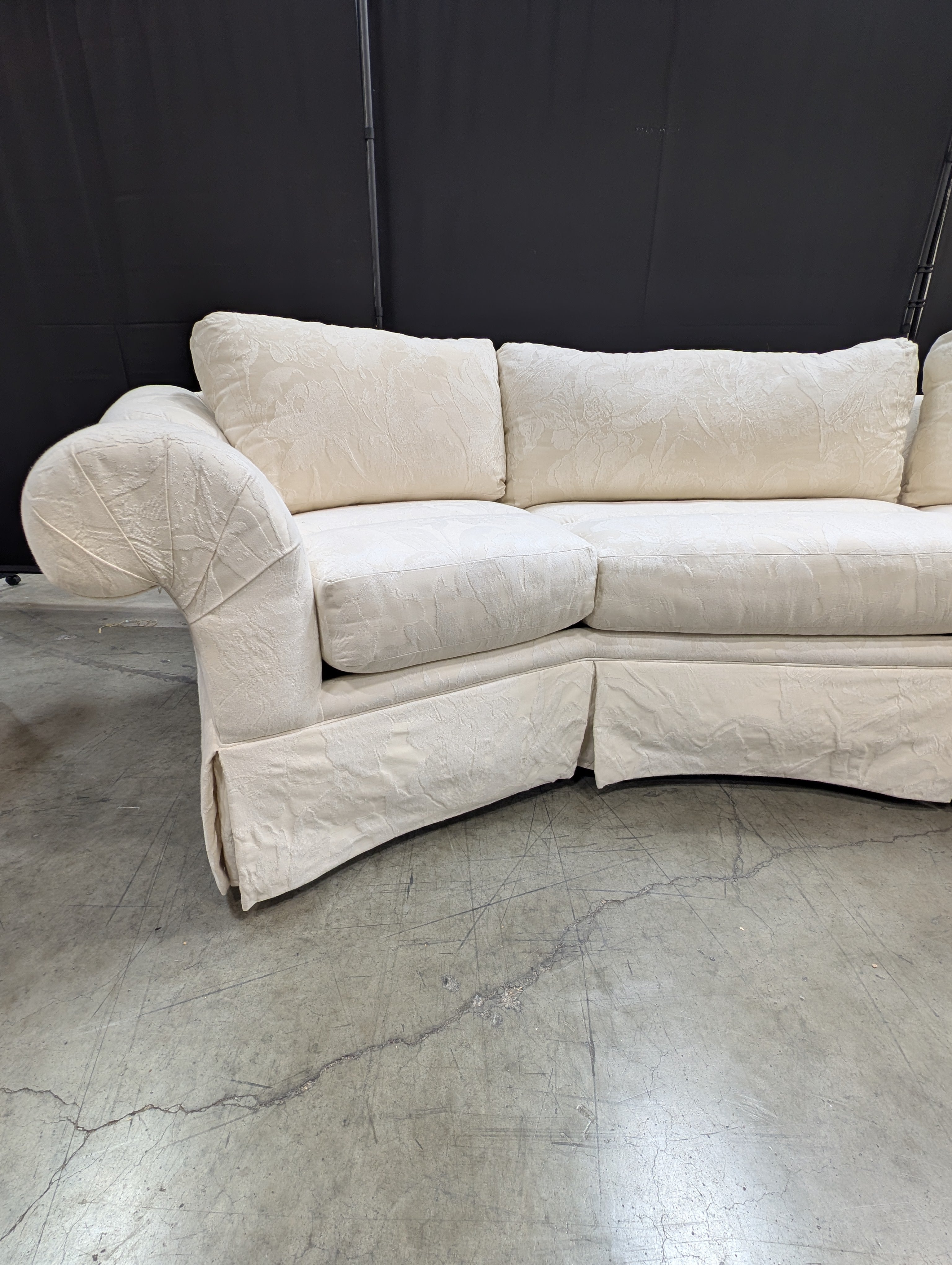 Has a stain Curved Cream Fabric Sectional Sofa with Rolled Arms