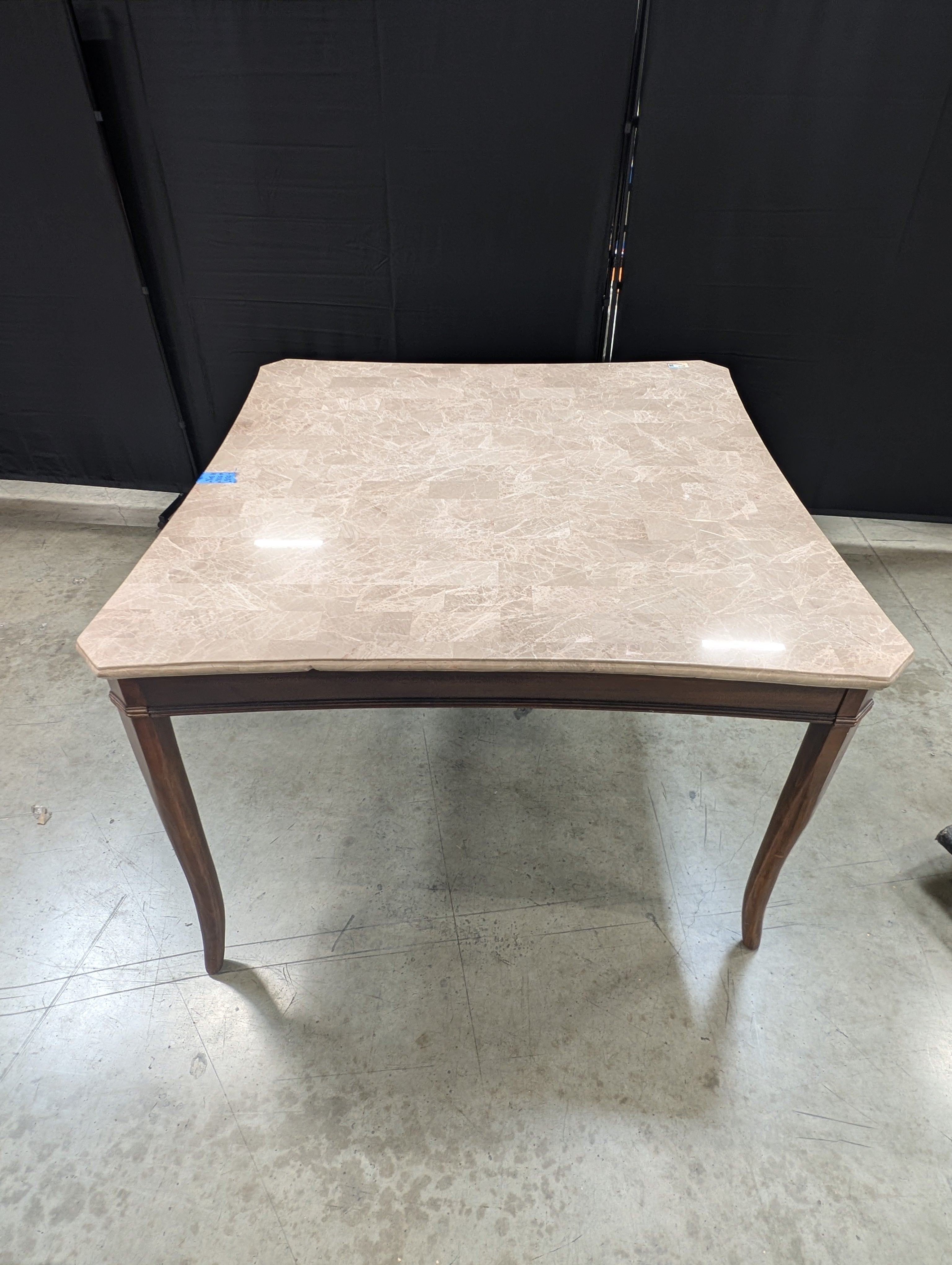 Stone Top Dining Table with Tapered Wood Legs has chip