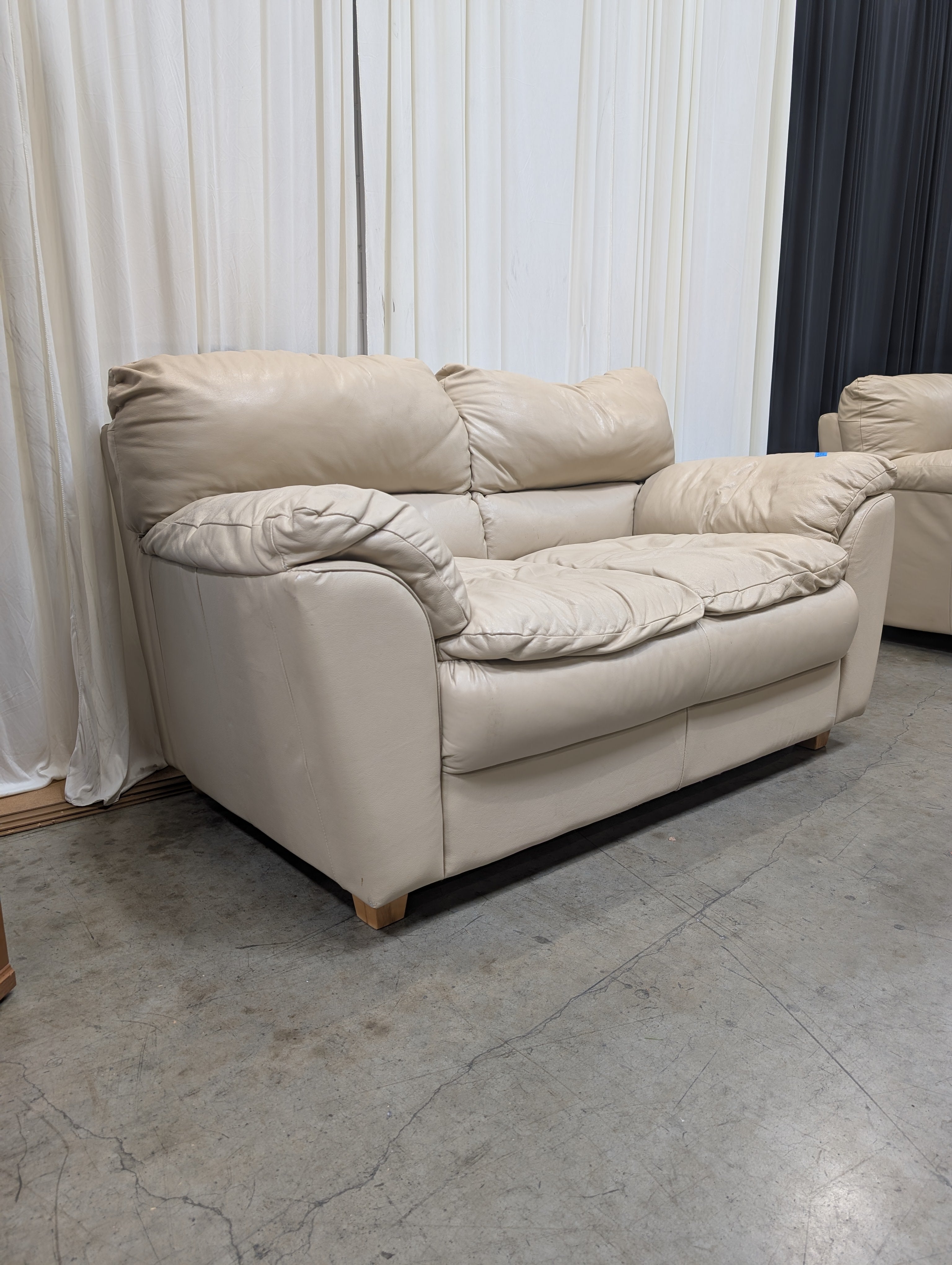 Cream Overstuffed Leather Loveseat with Padded Arms