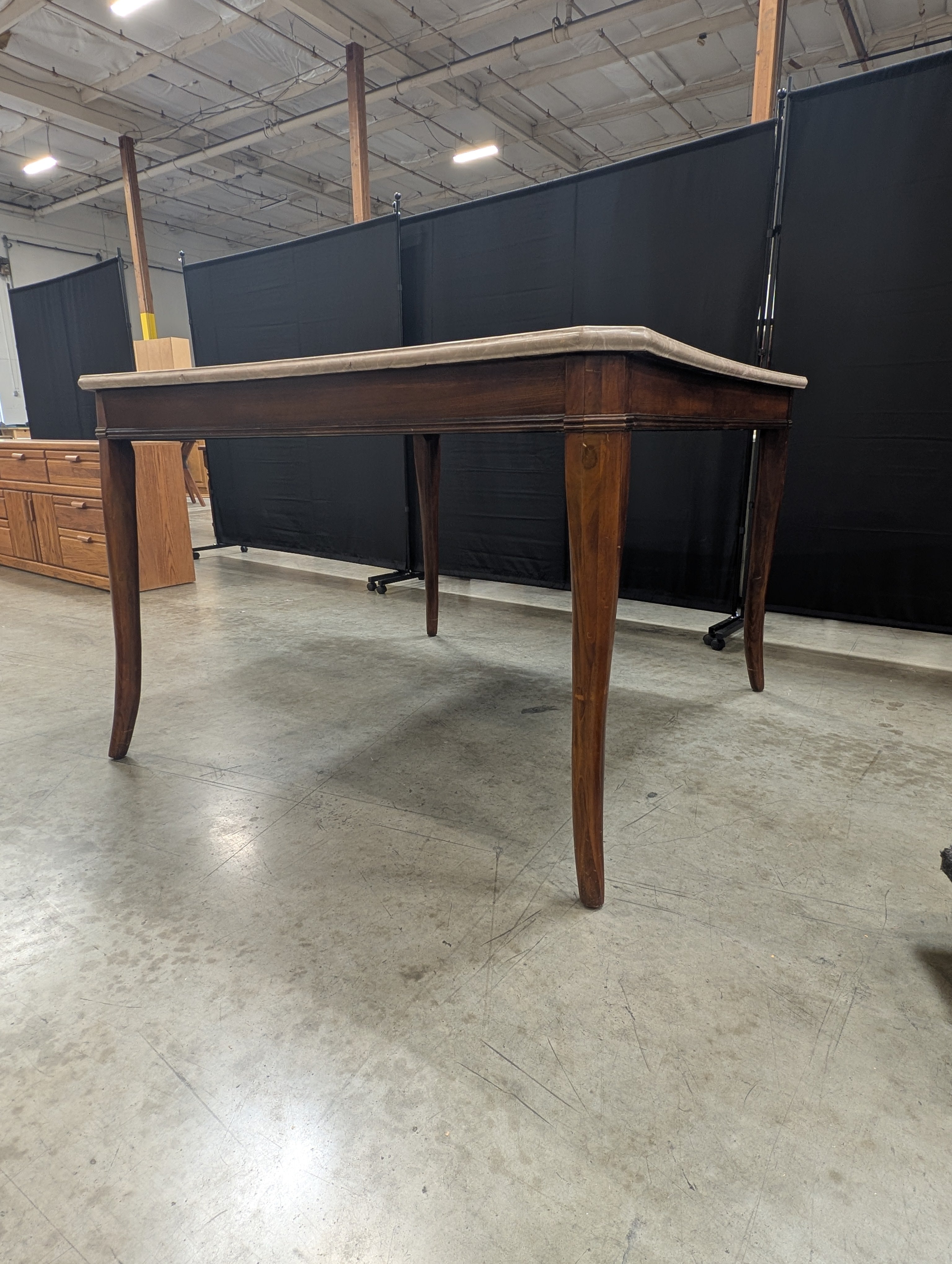 Stone Top Dining Table with Tapered Wood Legs has chip