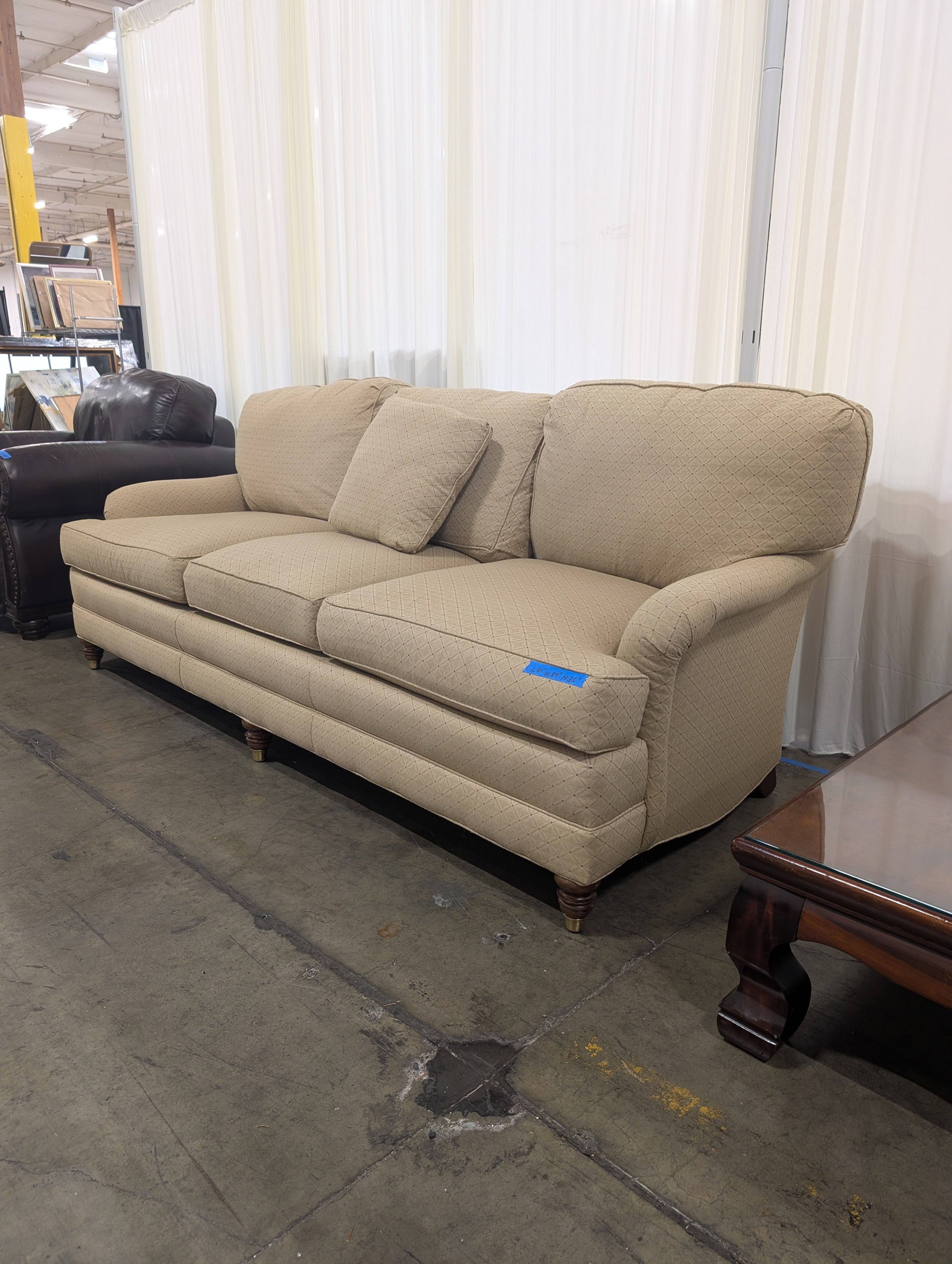 Tan Upholstered Three-Cushion Couch with Rolled Arms