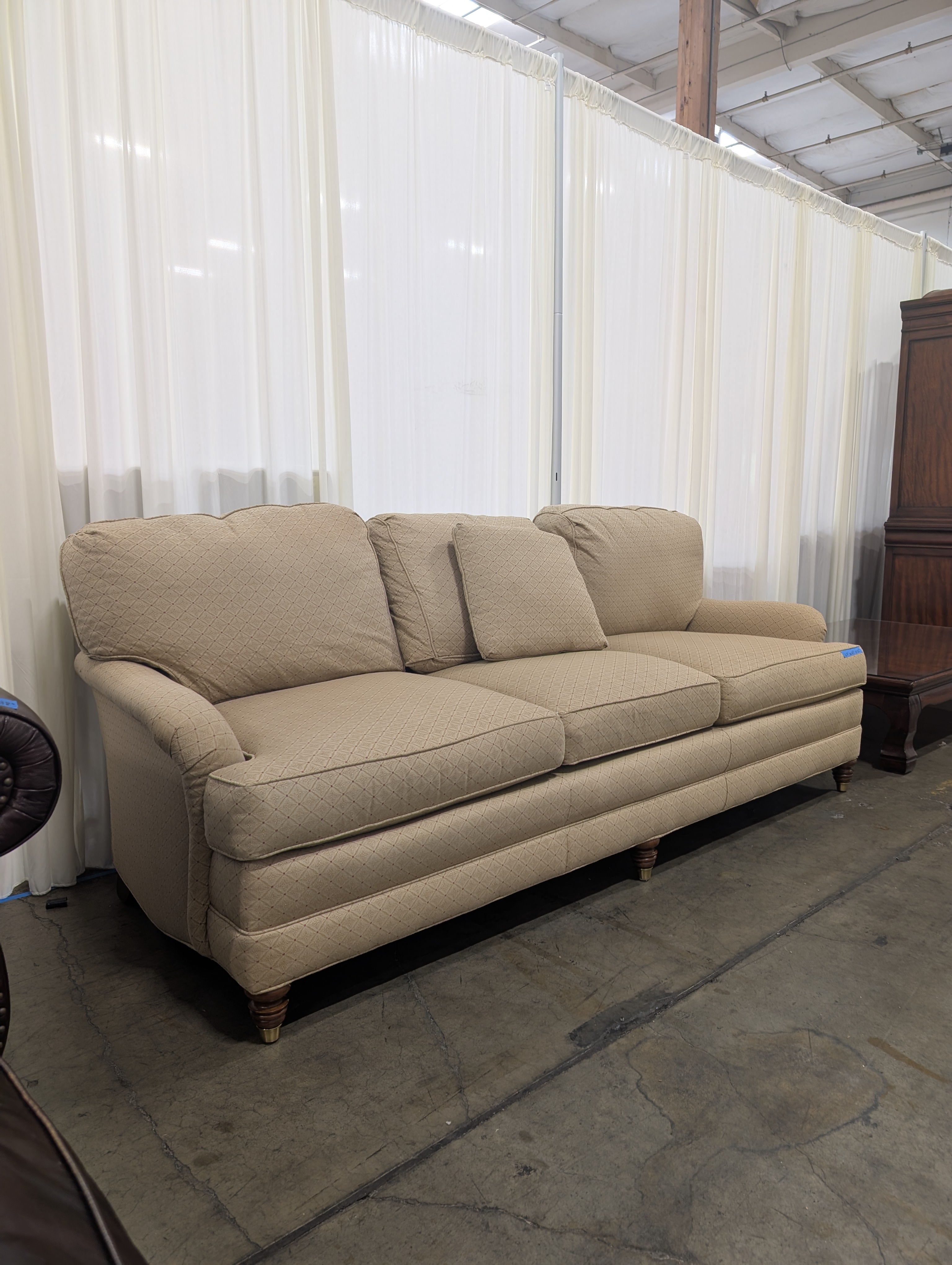 Tan Upholstered Three-Cushion Couch with Rolled Arms