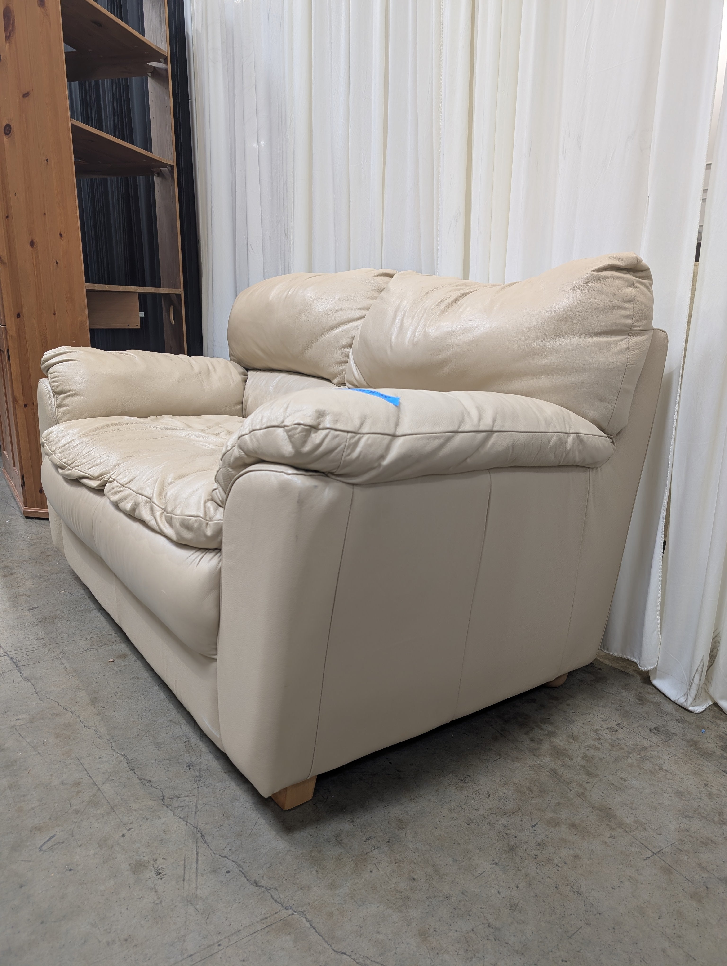 Cream Overstuffed Leather Loveseat with Padded Arms