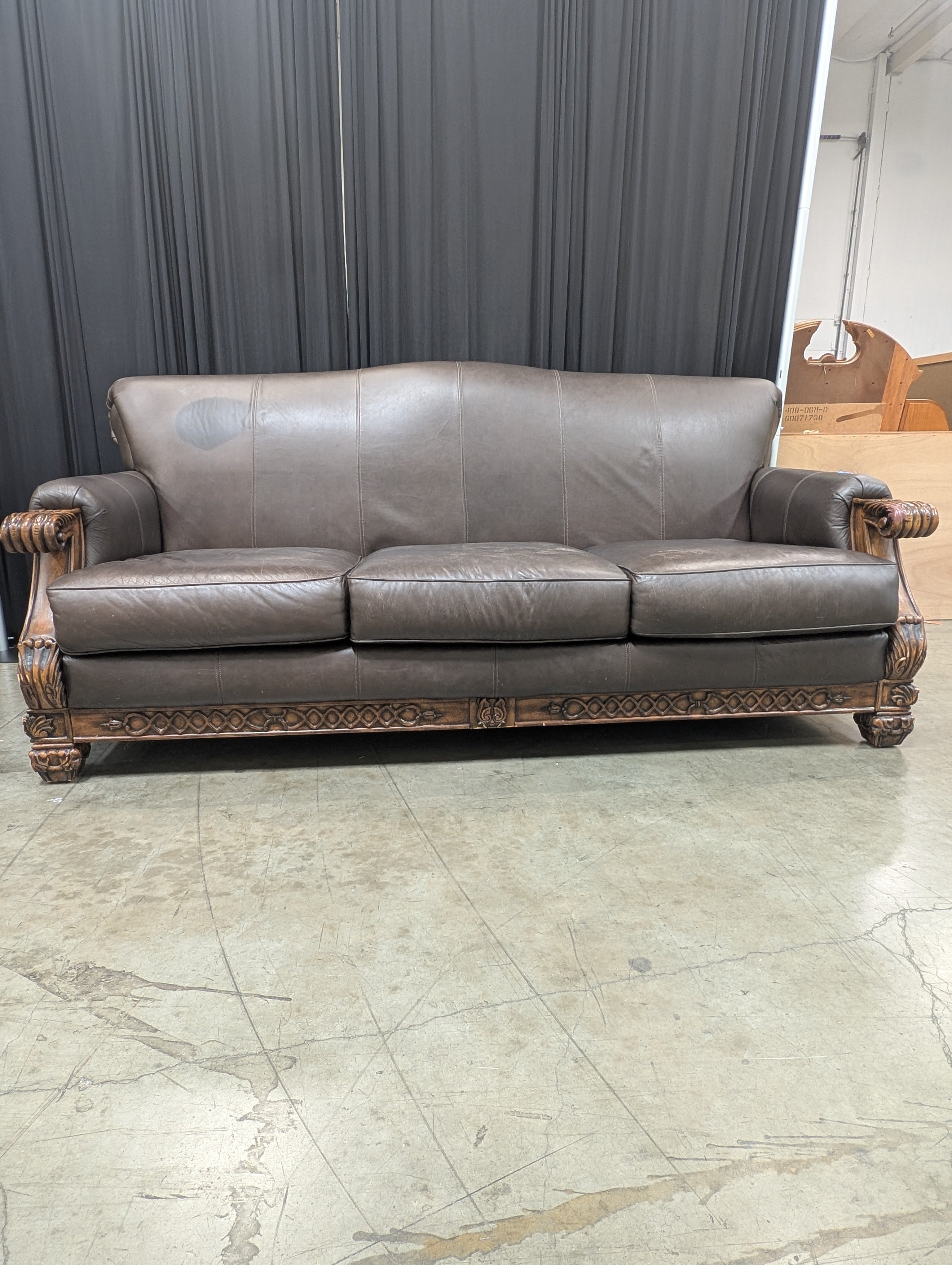 Ornate Brown Leather Couch with Carved Wood Trim